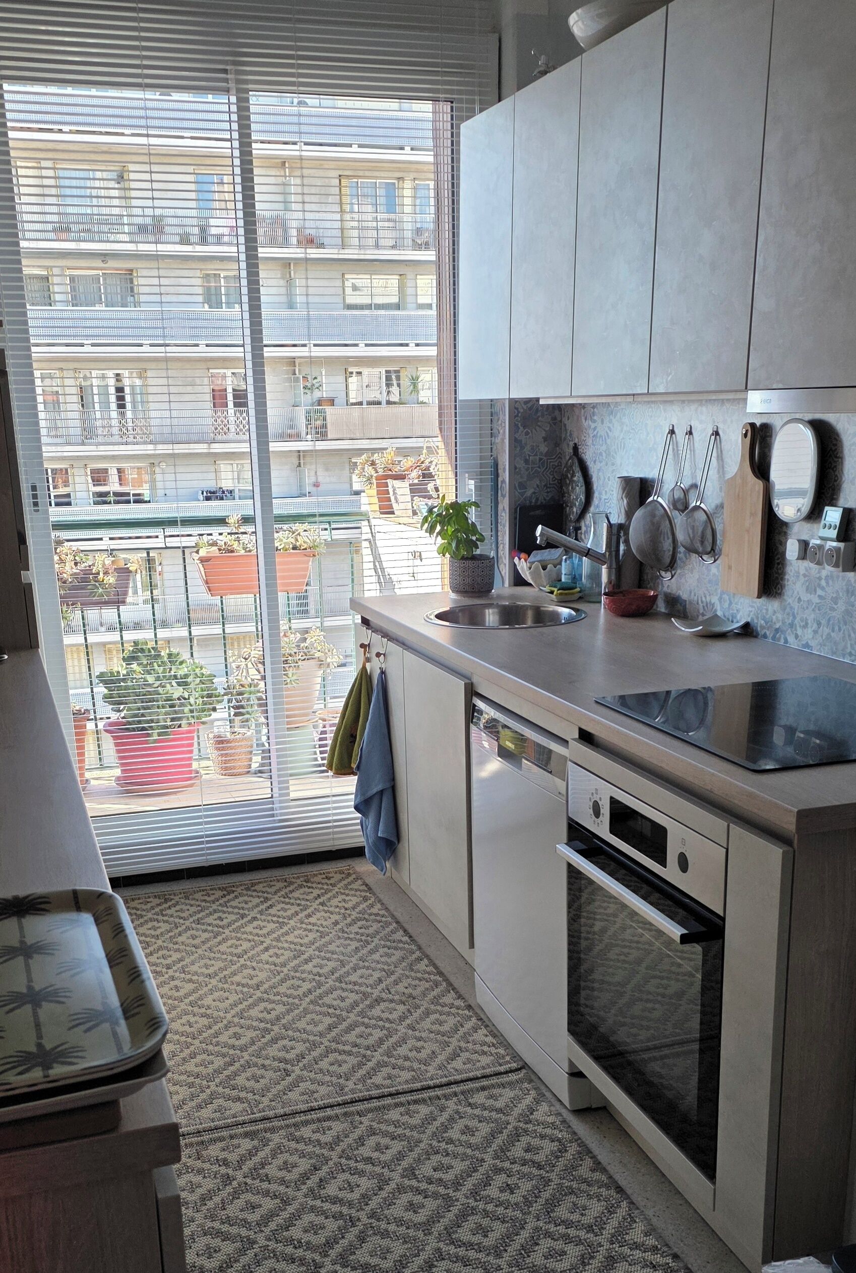 Una cucina moderna con un'ampia finestra, un lavandino e un forno integrato.