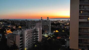 A cityscape at dusk with buildings and a sunset.