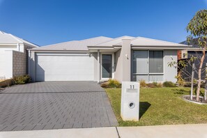 A modern two-story house with a garage, a well-maintained lawn, and a mailbox. - Lovely Lake Treeby Home | 1 Min to Park & Playgrounds (Treeby)