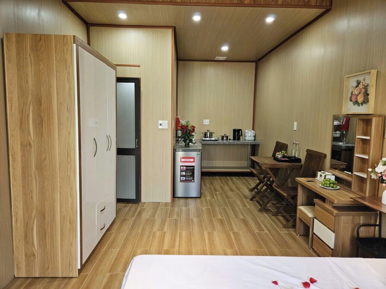 Una habitación compacta con cama, kitchenette, comedor y armario.