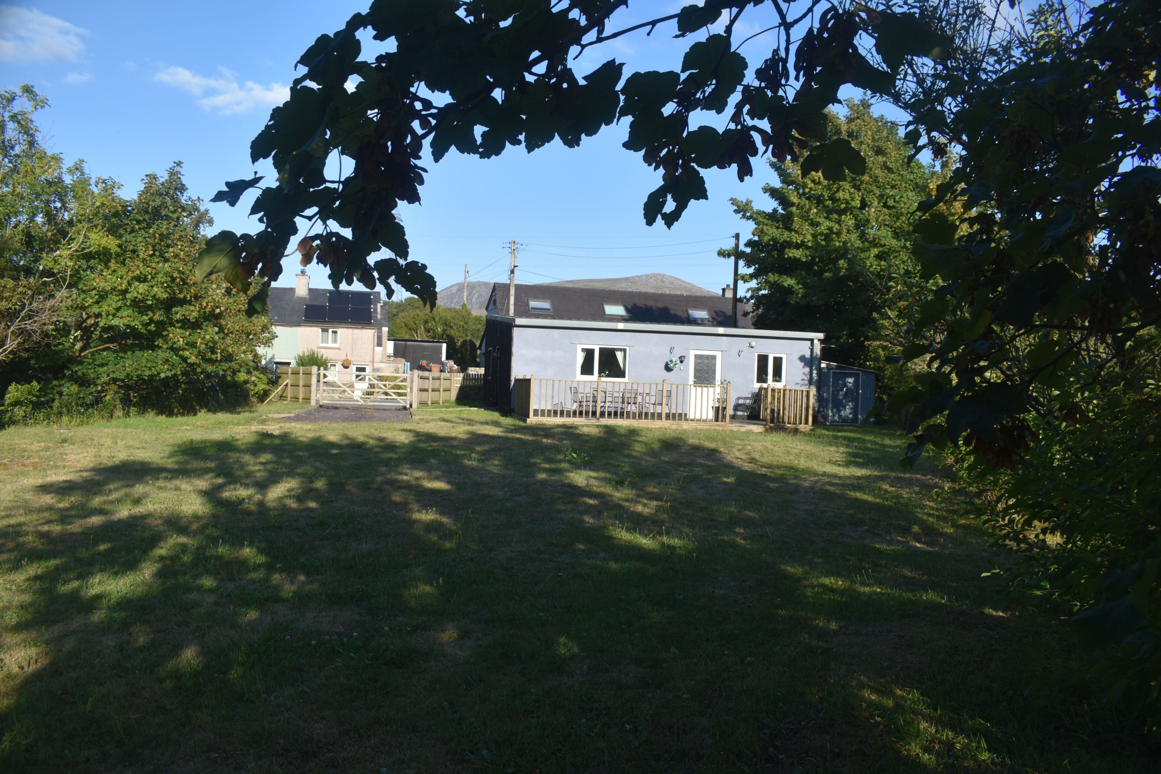 A residential property with a detached house, a garage, and a fenced yard.