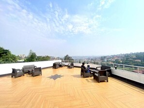 Eine Dachterrasse mit Gartenmöbeln und Blick auf die Stadt.