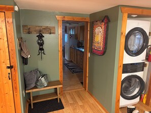 A laundry room with a washing machine, a bench, and a 'Welcome to the Man Cave' sign. - 7 Pines Cabin Hunt, Fish & Ride (Mountain)