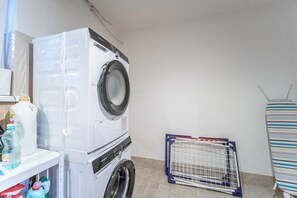 A laundry area with a white washing machine, a drying rack, and various cleaning supplies. - Wonderful 9-bedroom villa in Karlovy Vary for your getaway (Karlovarský kraj)