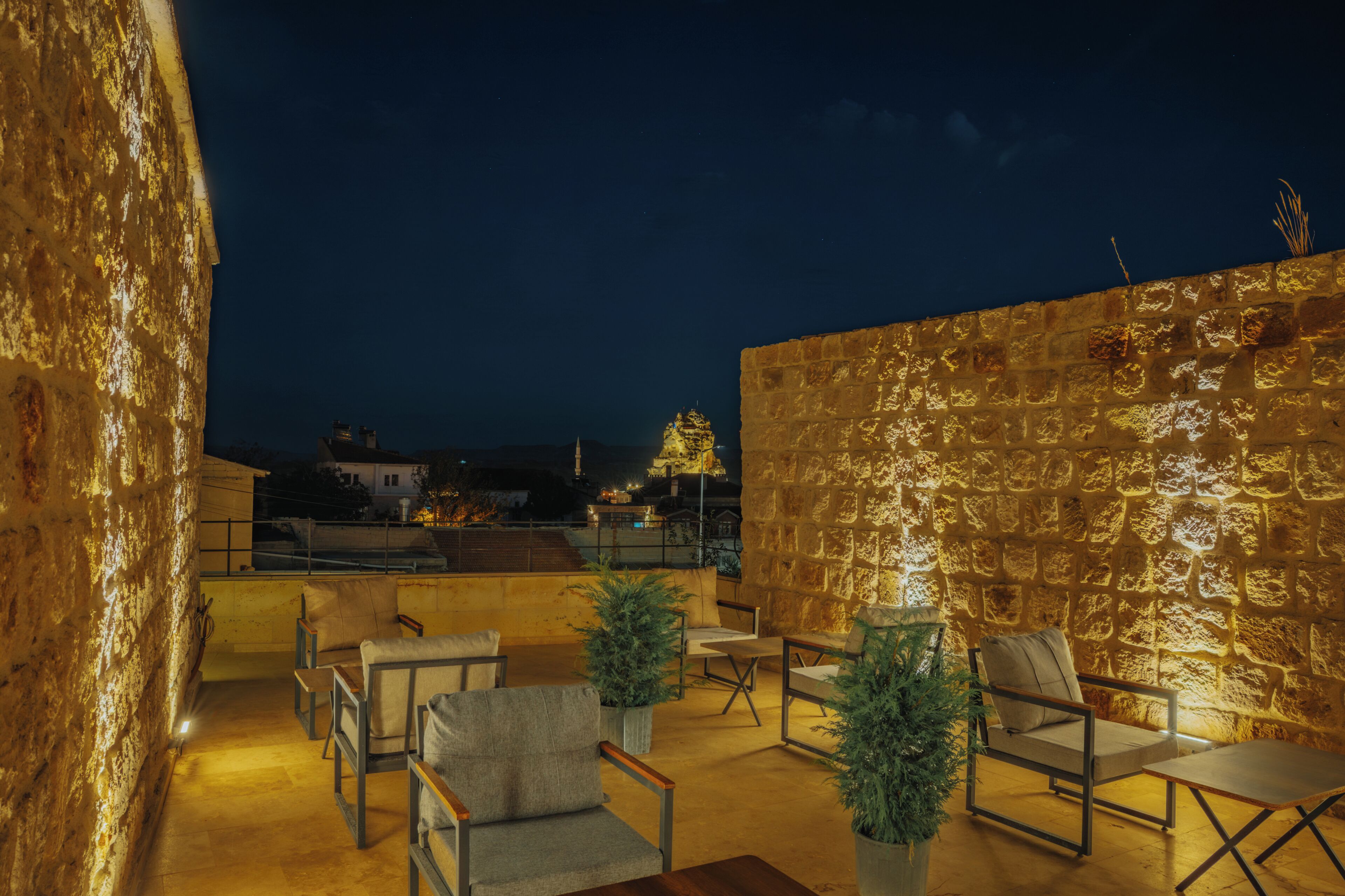 An outdoor seating area with stone walls and chairs.