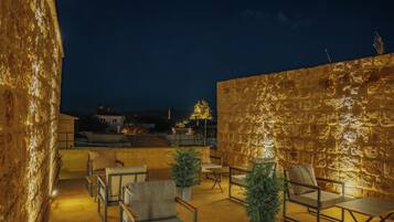 An outdoor seating area with stone walls and chairs.