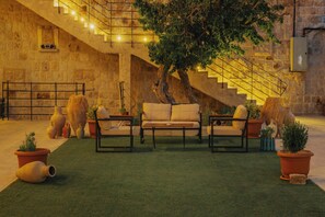A courtyard with a staircase, a sofa set, and potted plants. - Cappa Hisar Cave House (Ortahisar)