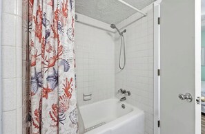 A bathroom with a shower, a bathtub, and a curtain with a floral pattern. - 8BR Beach House | Sleeps 20+ | Walk to Beach (North Myrtle Beach)