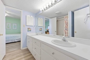 A bathroom with a large mirror, two sinks, and a vanity with drawers. - 8BR Beach House | Sleeps 20+ | Walk to Beach (North Myrtle Beach)