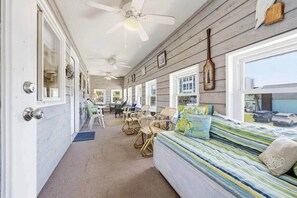 A room with a bed, chairs, a ceiling fan, and a view of the outside. - 8BR Beach House | Sleeps 20+ | Walk to Beach (North Myrtle Beach)