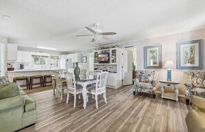 A spacious living area with a dining table, chairs, sofas, and a ceiling fan. - 8BR Beach House | Sleeps 20+ | Walk to Beach (North Myrtle Beach)