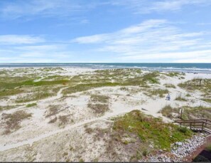 A beach with a wooden walkway leading to the water, sandy dunes, and a clear sky. - Beachfront Escape with Sunset and Marsh Views 14F (North Myrtle Beach)