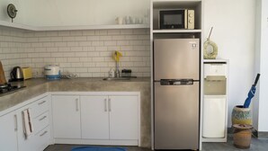 A compact kitchen with a stainless steel refrigerator, a microwave, and a sink. - Cozy and Private 1BR Casa Ku Villa in Seminyak (Badung)