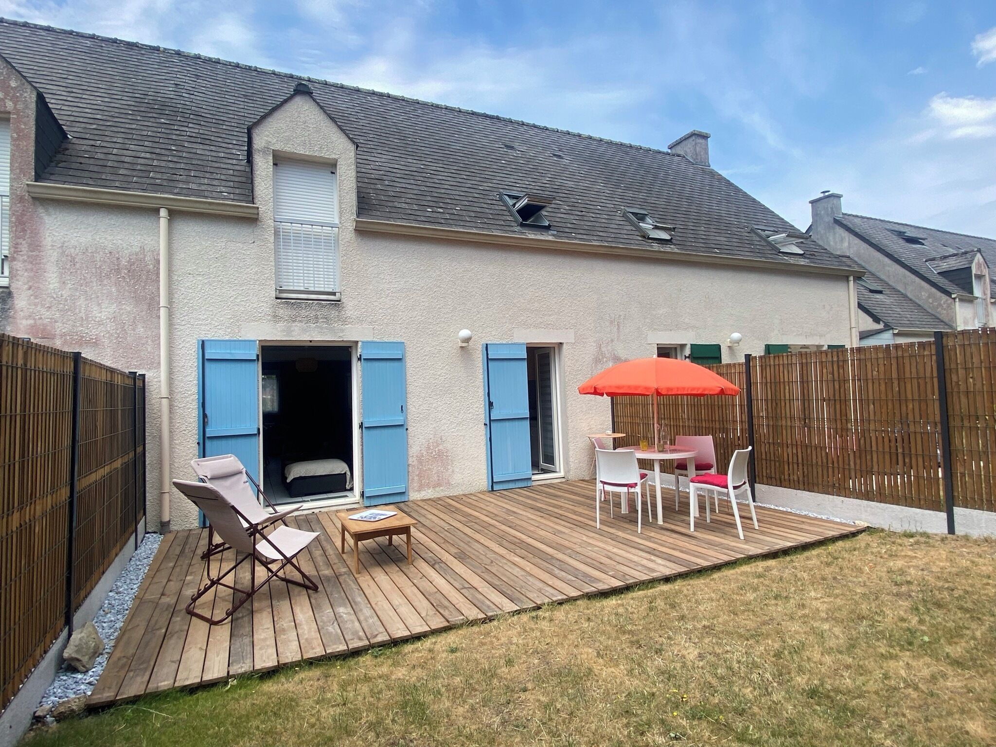 Il s’agit d’une propriété résidentielle dotée d’une terrasse en bois, d’un espace salon extérieur et d’un patio couvert.