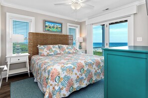 A bedroom with a bed, a nightstand, a lamp, a dresser, and a view of the ocean. - Oceanfront Luxury 8BR w/ Pool, Hot Tub, Theater, Game Room & Elevator (Atlantic Beach)