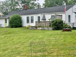 A single-story house with a front deck, a flag, and a fenced yard. - Spacious 4-Bedroom Pet-Friendly Home Near Antietam & Historic Sharpsburg (Sharpsburg)