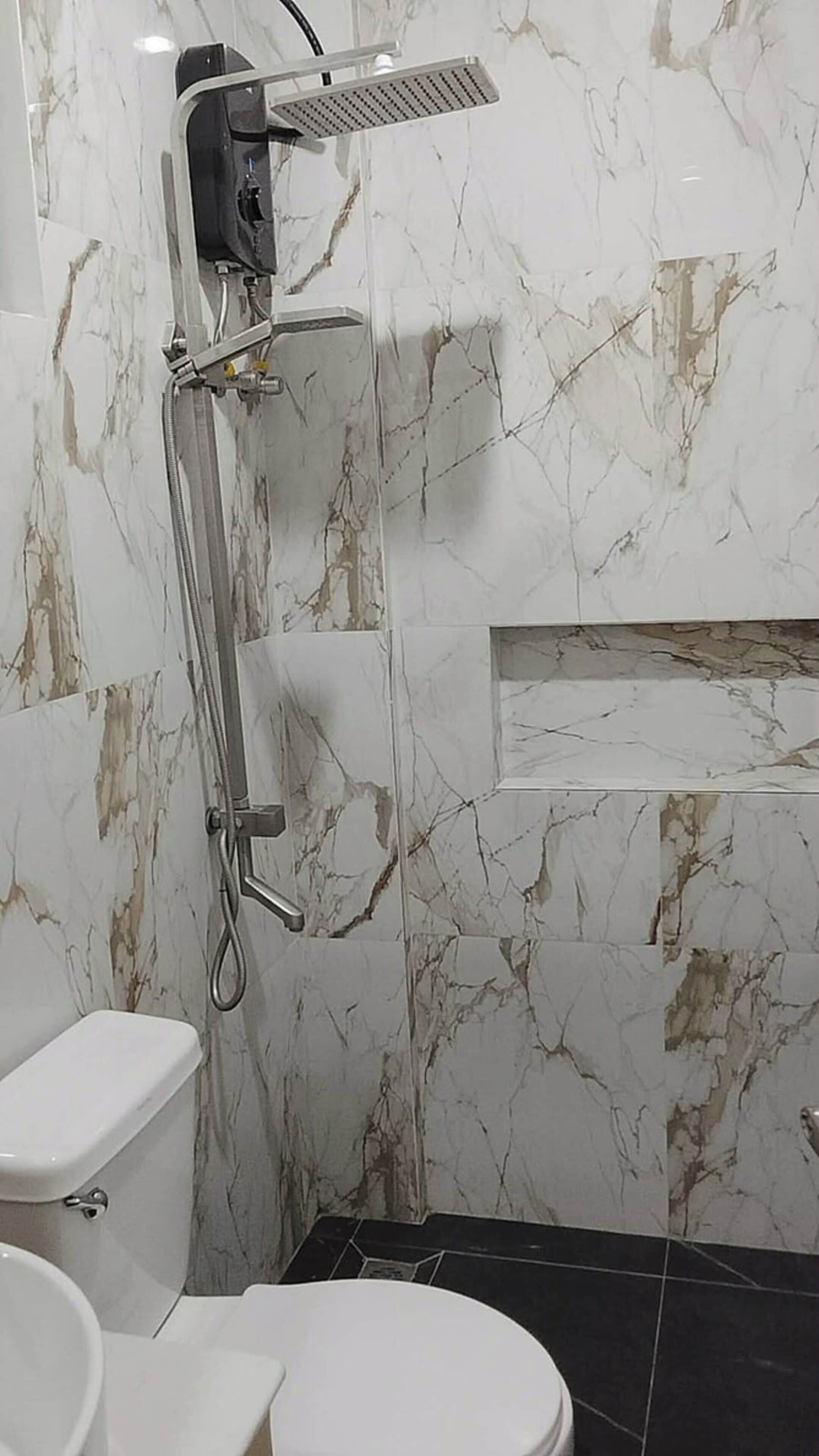 A bathroom with a shower, toilet, and sink.