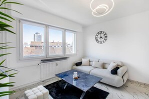 Una sala moderna con un sofá, una mesita de centro y un reloj de pared.