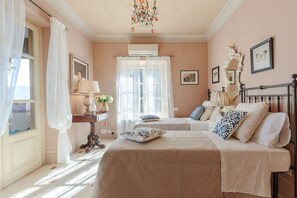 Ein Schlafzimmer mit einem Bett, Nachttischen, einem Spiegel und einer Kristallleuchter.