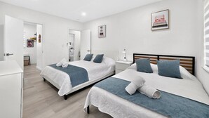 Habitación de hotel con dos camas, un escritorio y un baño.
