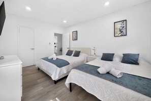 A hotel room with two beds, a desk, and a television. - Modern Miami Stay - Near Airport & Downtown (Miami)