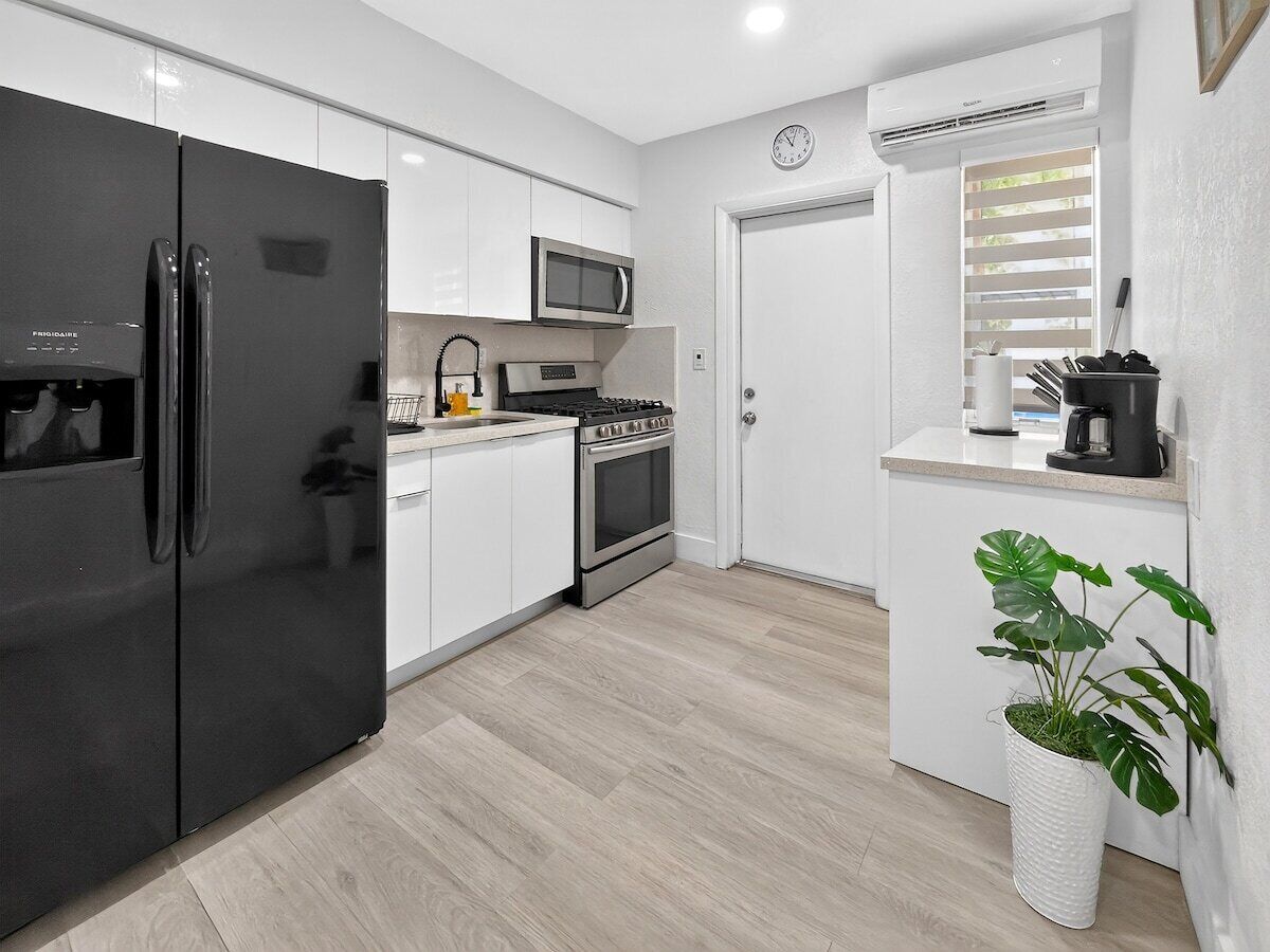 A modern kitchen with a refrigerator, stove, microwave, and sink.