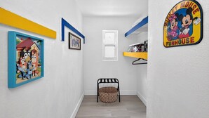 A hallway with a framed picture, a door, a basket, and a wall sign. - Modern Miami Stay - Near Airport & Downtown (Miami)