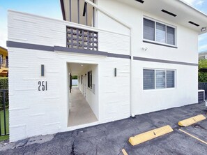 Un bâtiment moderne à deux étages, doté d’un portail de garage portant le numéro « 251 » et d’une entrée bien visible.