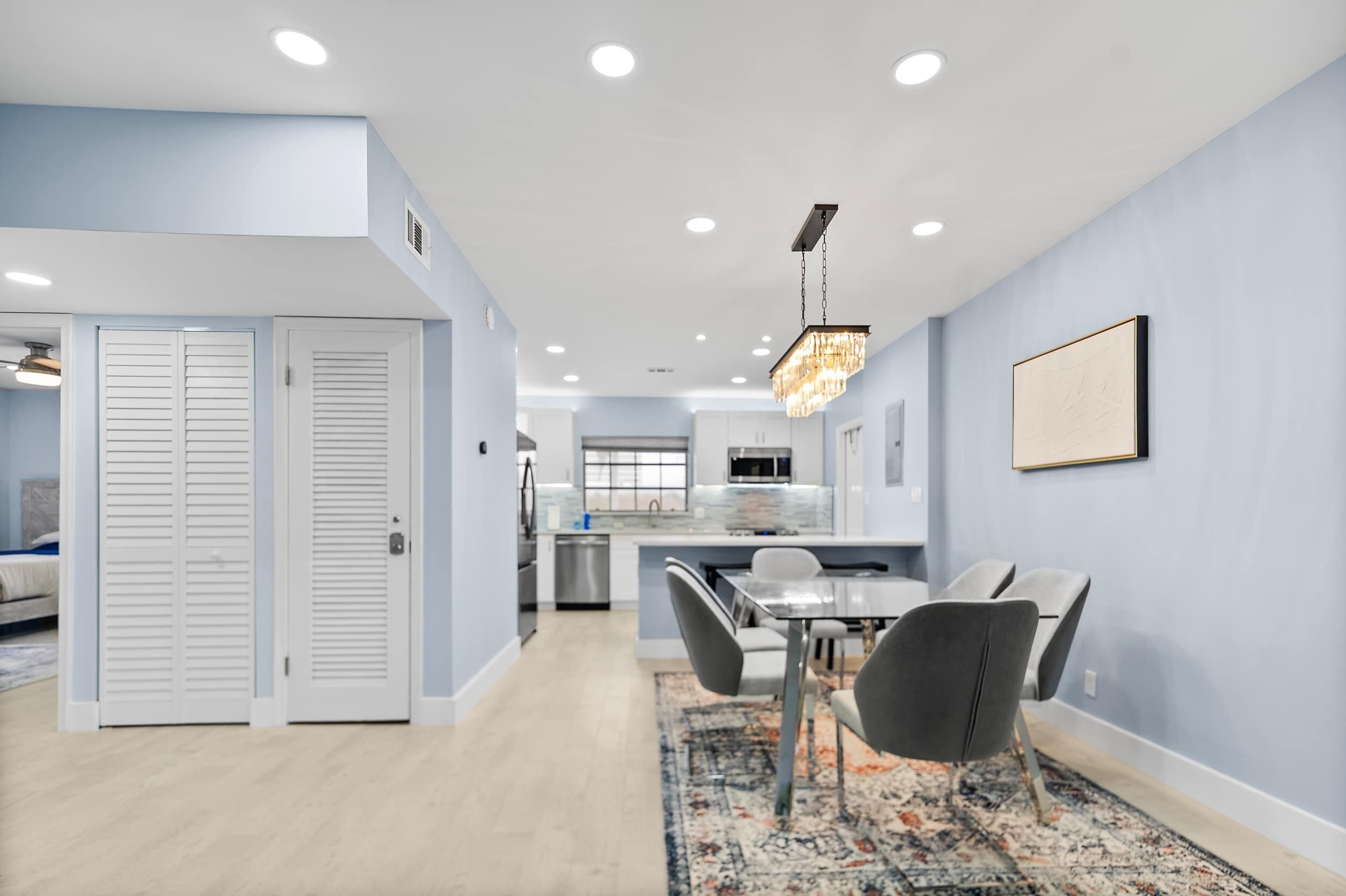 A modern kitchen with white cabinets, a stainless steel refrigerator, and a built-in oven.