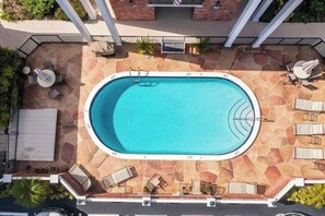 A rooftop swimming pool with a stone deck, surrounded by lounge chairs and umbrellas. - 1BR Sunrise Oasis with Pool Near Beach & Las Olas (Fort Lauderdale)