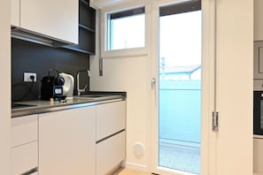 Eine Küche mit Einbauherd, Spüle und Fenster.