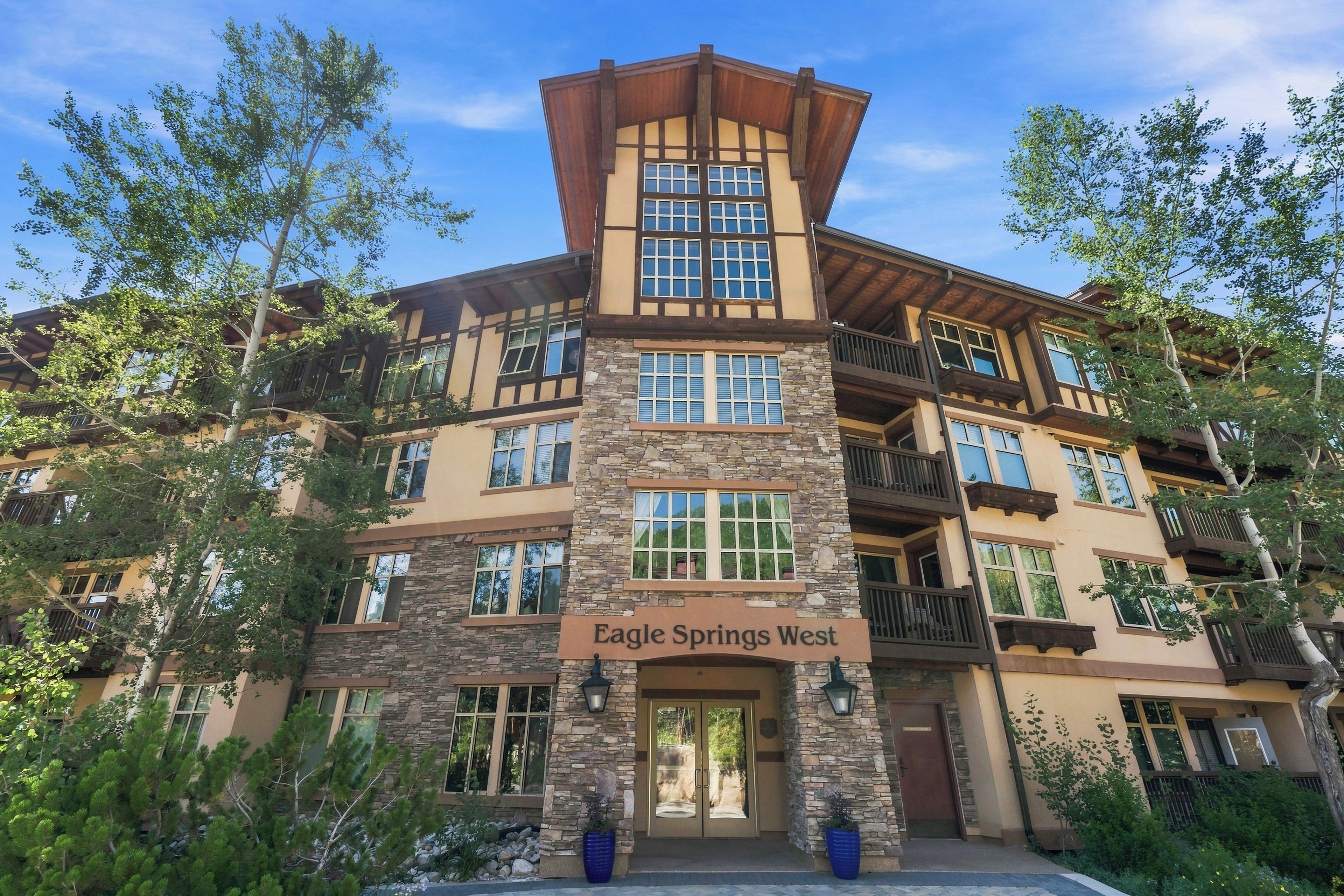 A multi-story building with a stone facade and a sign reading 'Eagle Springs West.'