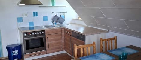 Una cucina compatta con fornello, forno e arredamento moderno.