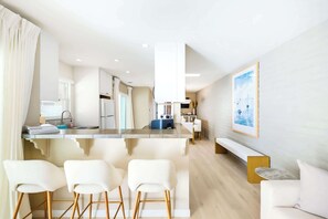 A modern kitchen with a central island, bar stools, and a dining area with a bench. - Casa Del Mar - Designer Home, 1 Block to Beach (Del Mar)