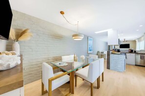 A modern kitchen with a central island, white cabinetry, and a built-in oven. - Casa Del Mar - Designer Home, 1 Block to Beach (Del Mar)