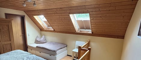 Un dormitorio con cama, escritorio, silla y escalera.