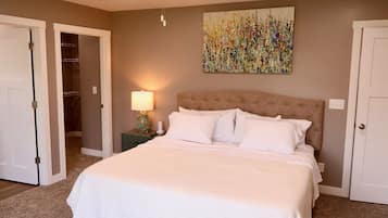A bedroom with a bed, a nightstand, a lamp, and a ceiling fan.