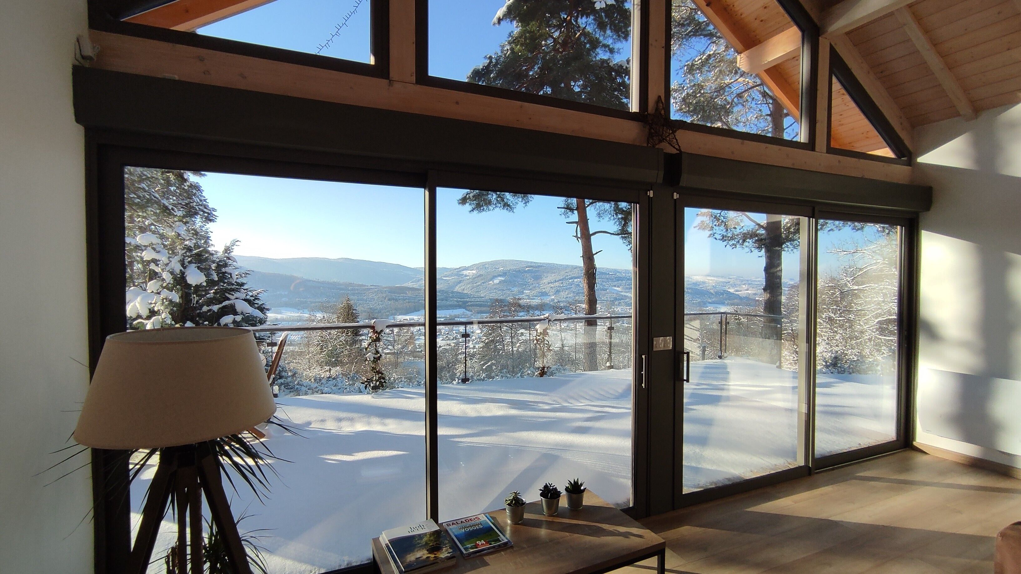 A room with large windows offering a snowy mountain view.