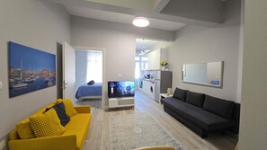 A modern living room with a sofa, a coffee table, and a flat-screen TV. - KYANA Luxury KVA (Kavala)