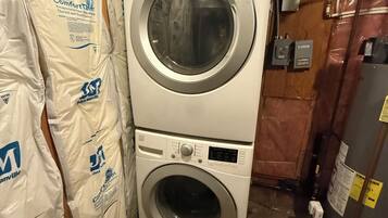 Una lavadora y secadora apiladas, con panel de control visible y etiquetas de marca.