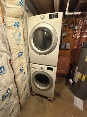 A stacked washer and dryer unit with visible control panel and brand labels.
