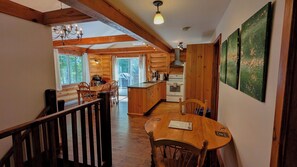 Un intérieur en bois comprenant un coin repas, une cuisine et un escalier.