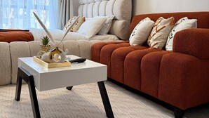A living room with a sofa, a coffee table, and a decorative plant. - Cozy studio bed & breakfast in quaint Nairobi with 
swimming pool (Nairobi)