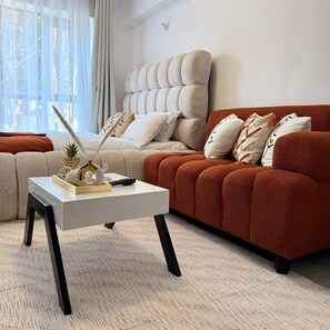 A living room with a sofa, a coffee table, and a decorative plant. - Cozy studio bed & breakfast in quaint Nairobi with 
swimming pool (Nairobi)