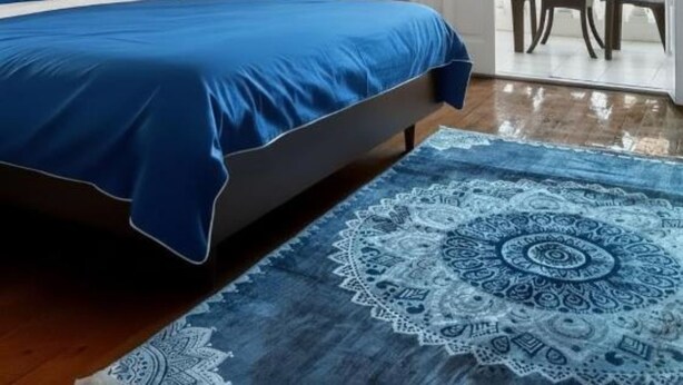 Un dormitorio con cama, mesita de noche, espejo y vistas a un espacio exterior a través de una puerta.