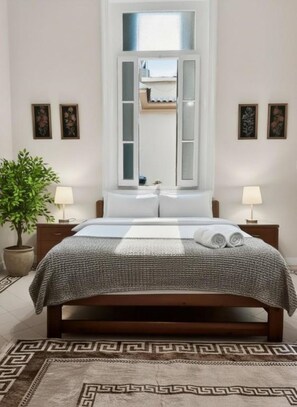 A bedroom with a bed, bedside lamps, a window, and a potted plant. - Stunning specious luxury apartment high ceiling (Cairo Governorate)