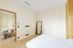 A modern bedroom with a bed, a desk with chairs, and a mirror. - Modern a/c - 1bdr/4p Flat - Montorgueil (Paris)