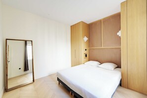 A bedroom with a bed, a wardrobe, and a mirror. - Modern a/c - 1bdr/4p Flat - Montorgueil (Paris)