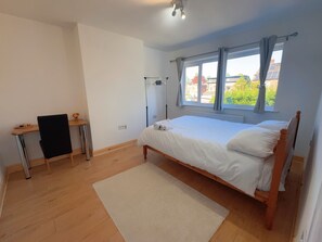 Ein Schlafzimmer mit einem Einzelbett, einem Schreibtisch und einem Stuhl.