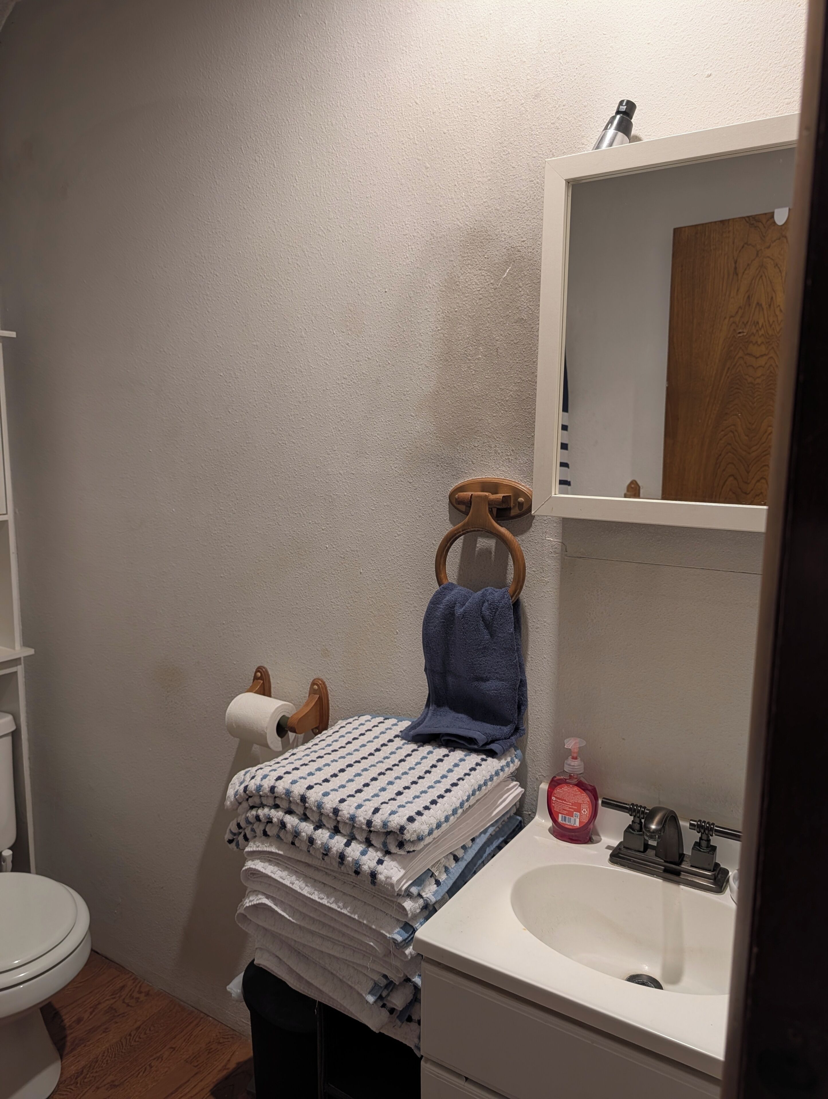 Une salle de bain avec des toilettes, un lavabo et un miroir.